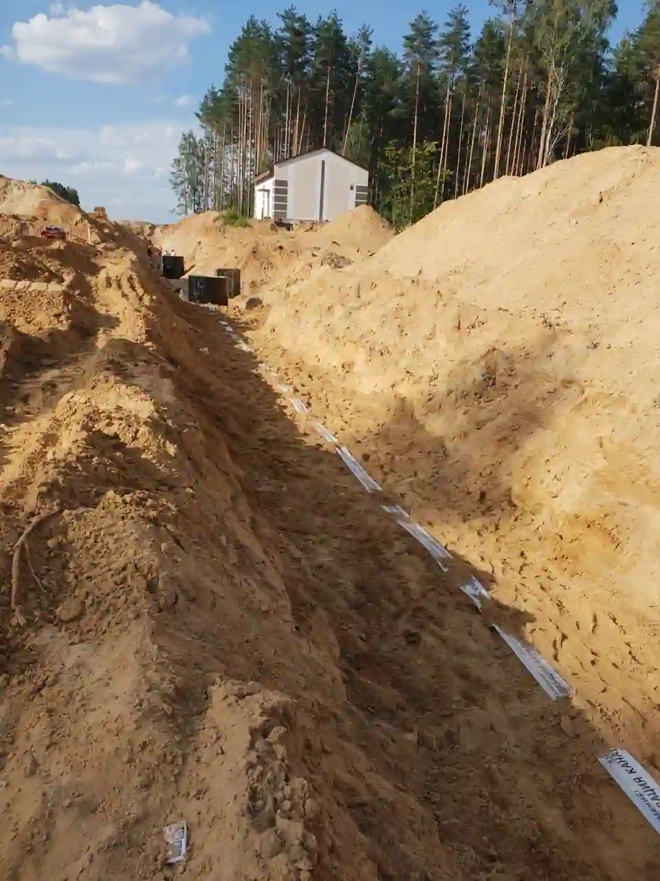 Копка траншей для ливневой канализации на строительной площадке парка Великий Камень в Минской области.