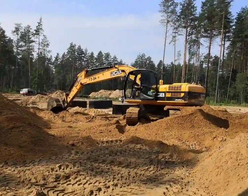 Вертикальная планировка участка экскаватором JCB при подготовке основания