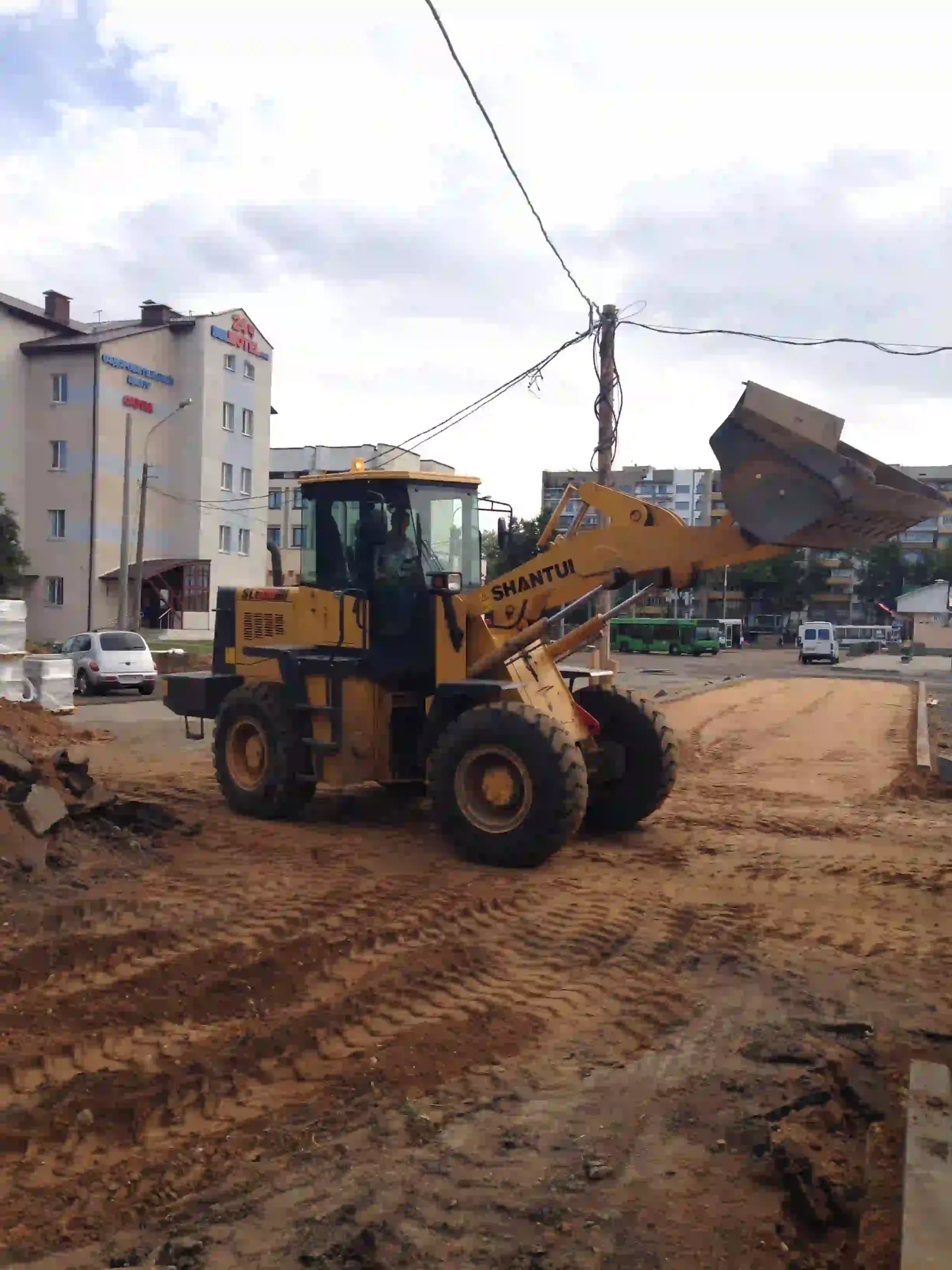 Вертикальная планировка улицы фронтальным погрузчиком при устройстве основания дороги